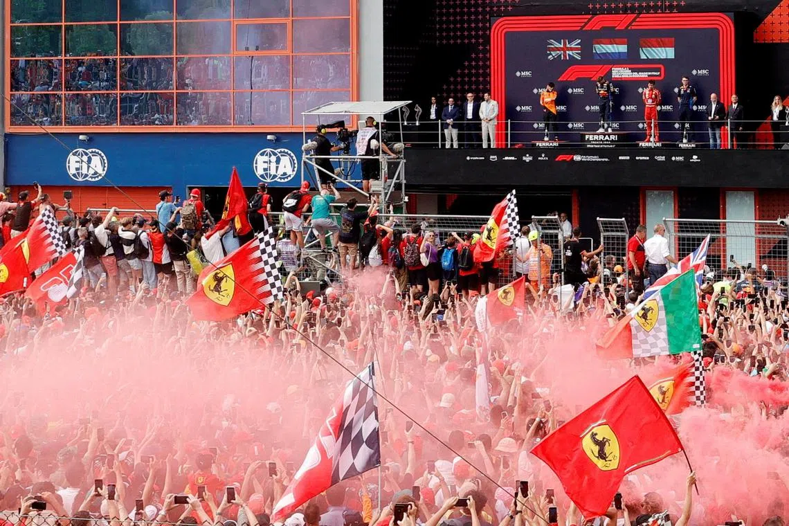 Red Bull's Max Verstappen celebrates on the podium after winning the Emilia Romagna Grand Prix along with second placed McLaren's Lando Norris and third placed Ferrari's Charles Leclerc on May 19, 2024.