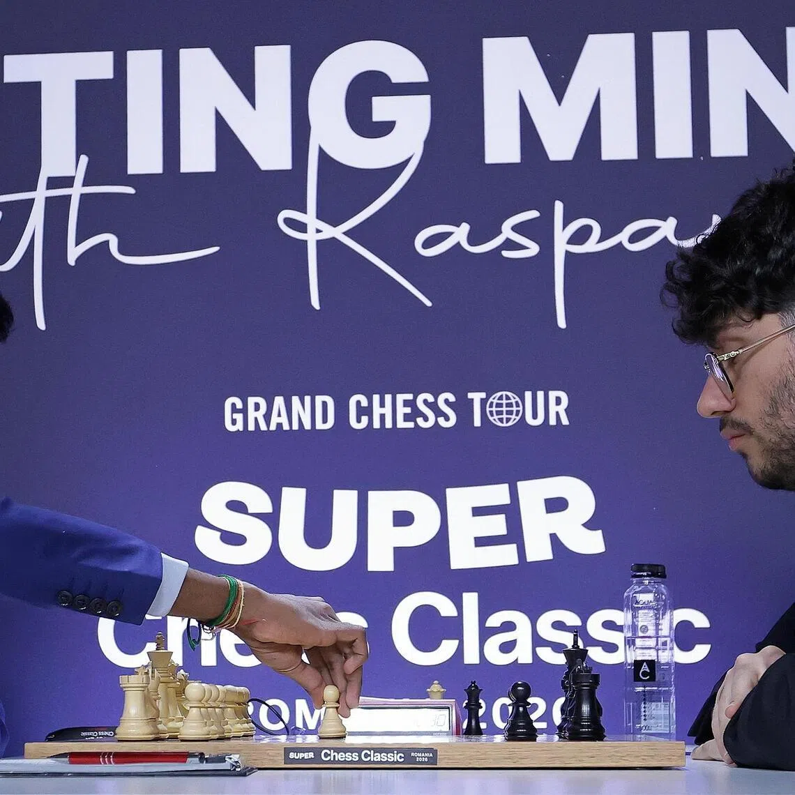 Indian chess grandchess Rameshbabu Praggnanandhaa (left), the world defending champion, makes the first move with the white pieces against Iranian-French chess grandmaster Alireza Firouzja on the first competion day for the 1-st stage of Grand Chess Tour - 'Super Chess Classic Romania 2026' - held at the National Bank of Romania Palace in Bucharest, Romania on May 14, 2026.