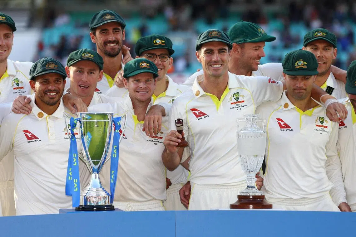 Australia's Pat Cummins and teammates pose with the urn and trophies after drawing the series and retaining the Ashes after the fifth Test against England at The Oval in London on July 31, 2023.