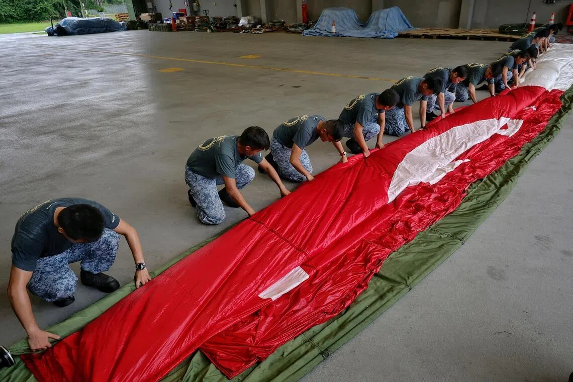 It takes several ground crew personnel to neatly fold the 317kg state flag.