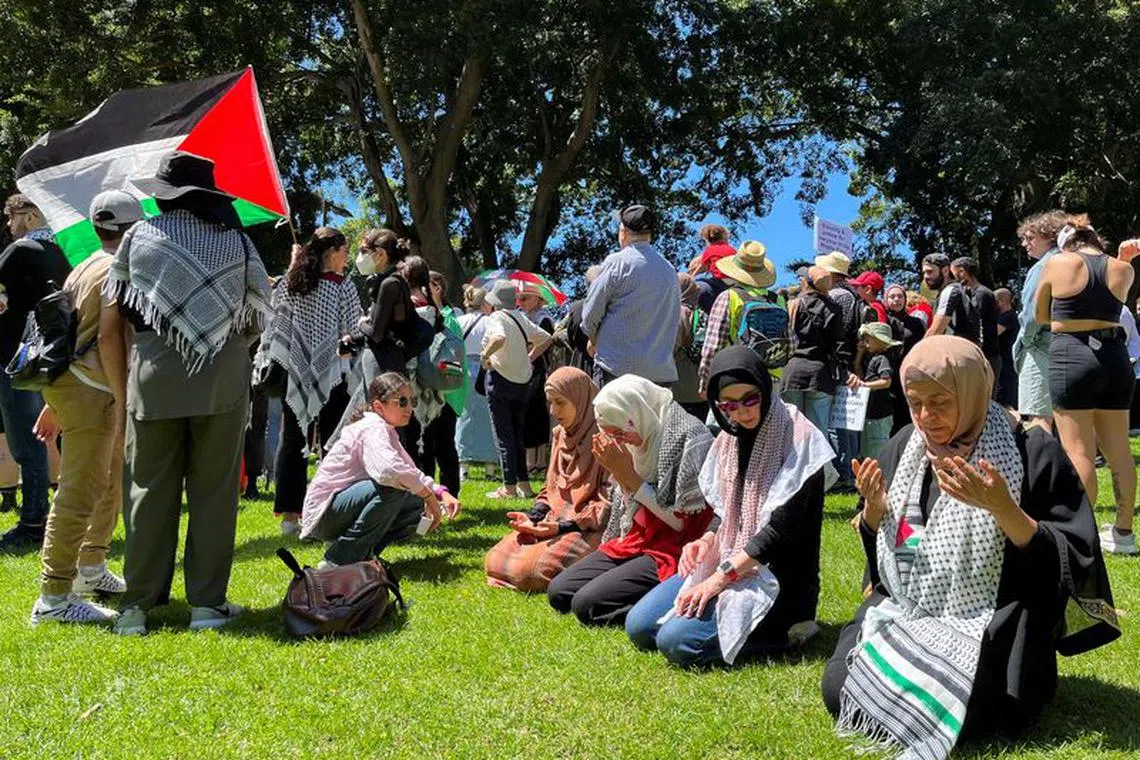Women pray before a pro-Palestinian rally in Hyde Park, Sydney, Australia October 15, 2023. REUTERS/Lewis Jackson