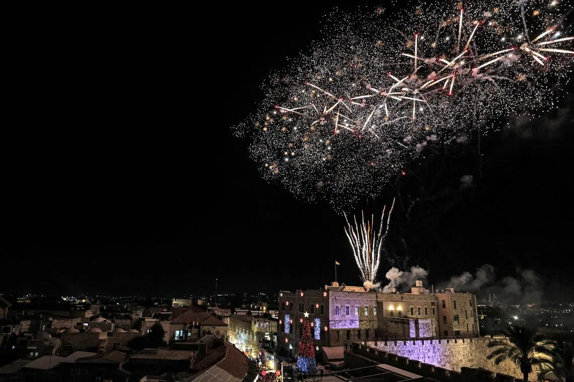 Fireworks light the sky to mark the lighting of the Christmas tree at the Jaffa Gate of the old city of Jerusalem on Dec 11, 2022. 