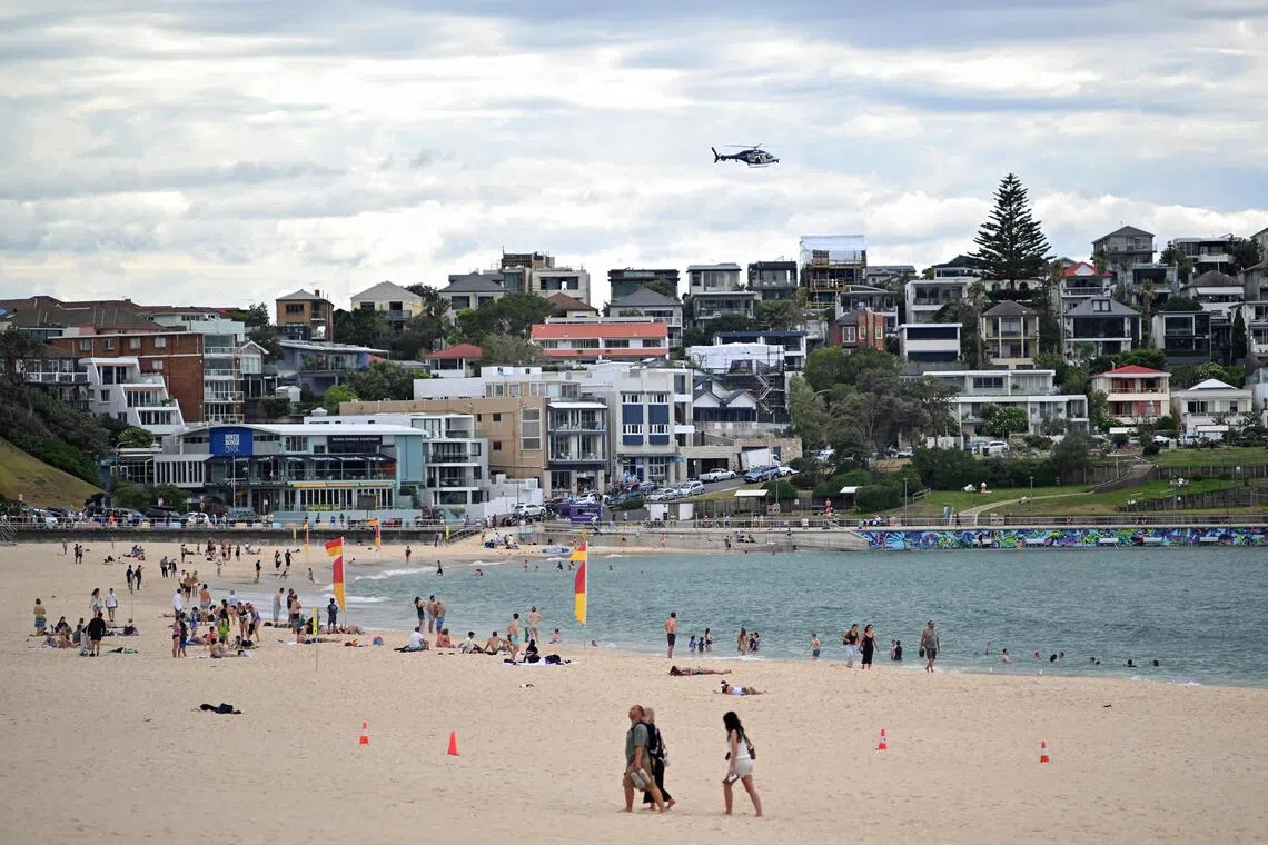 A police helicopter patrols over the Bondi Beach as life gradually returns to normal following seven days of mourning, a week after the Bondi Beach shooting attack, in Sydney on Dec 22, 2025.