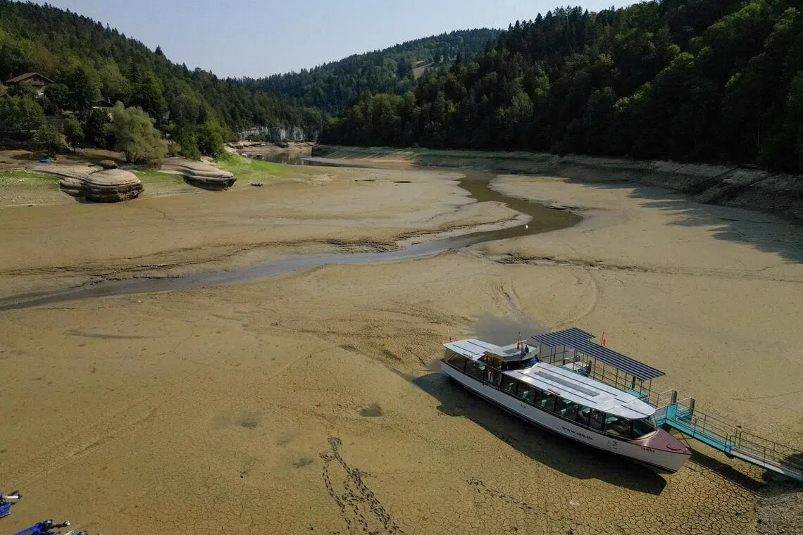A drone view shows a moored boat on the nearly empty Lake Brenets as drought conditions affect the Doubs River lower water levels along the Swiss-French border in Les Brenets, Switzerland, July 30.