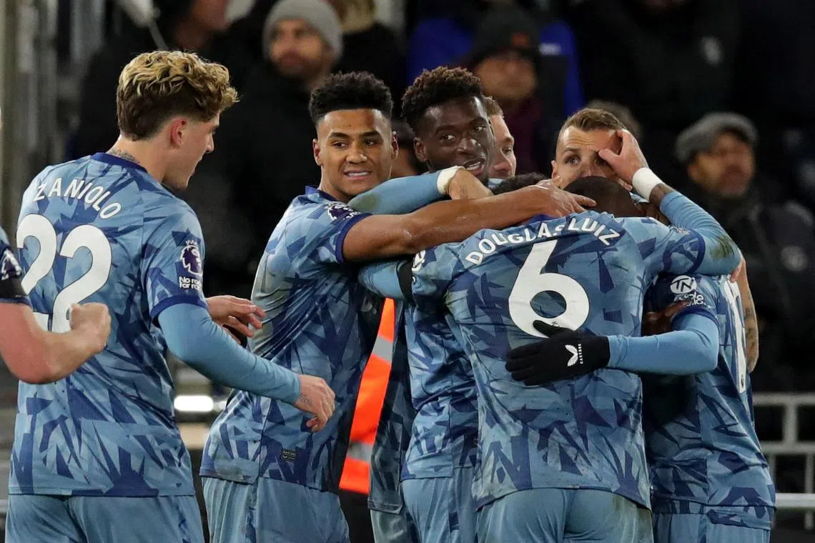 Aston Villa's Lucas Digne celebrates scoring their third goal with teammates.