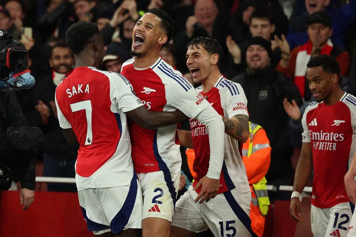 Arsenal's William Saliba (second from left) celebrates scoring his team's second goal with midfielder Bukayo Saka and defender Jakub Kiwior.