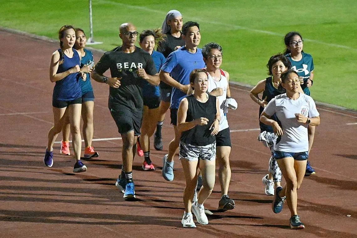 Anselm Chelliah (wearing black Bear tee shirt) with his team during their training for the Relay of Life at Bishan Stadium on March 6 , 2025 .