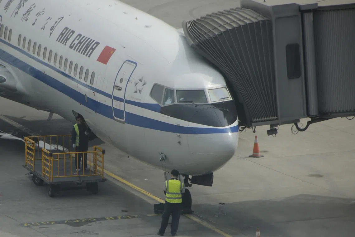FILE PHOTO: Workers work on a flight of Air China on the tarmac at the Beijing Capital International Airport in Beijing, China, March 28, 2016.REUTERS/Kim Kyung-Hoon/File Photo