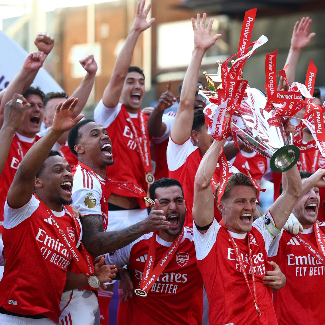 Arsenal’s Martin Odegaard lifts the trophy as he celebrates with teammates after winning the Premier League at Selhurst Park in London, Britain, on May 24.