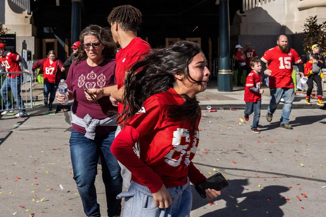 People flee after shots are fired near the Kansas City Chiefs' Super Bowl victory parade, in Kansas City, Missouri.