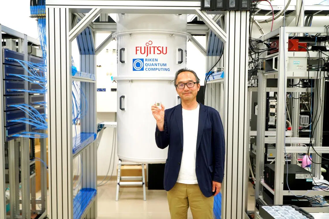 Dr Shintaro Sato, who heads the quantum laboratory at Fujitsu Research, holds up the 64-qubit chip that powers the quantum computer jointly developed by Fujitsu with Riken, or the Institute of Physical and Chemical Research, in Wako City.