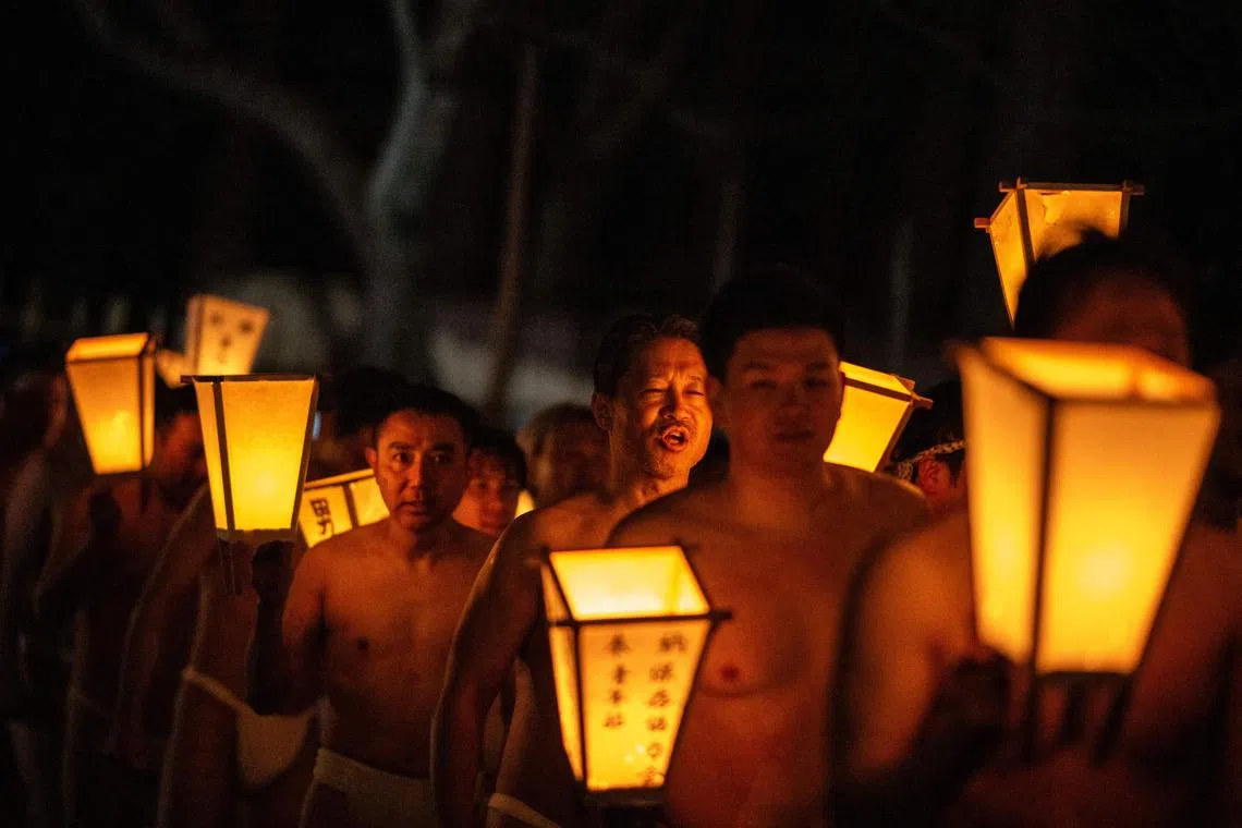 Men carry lanterns as they walk to a river to cleanse their bodies during the Sominsai festival on Feb 17.