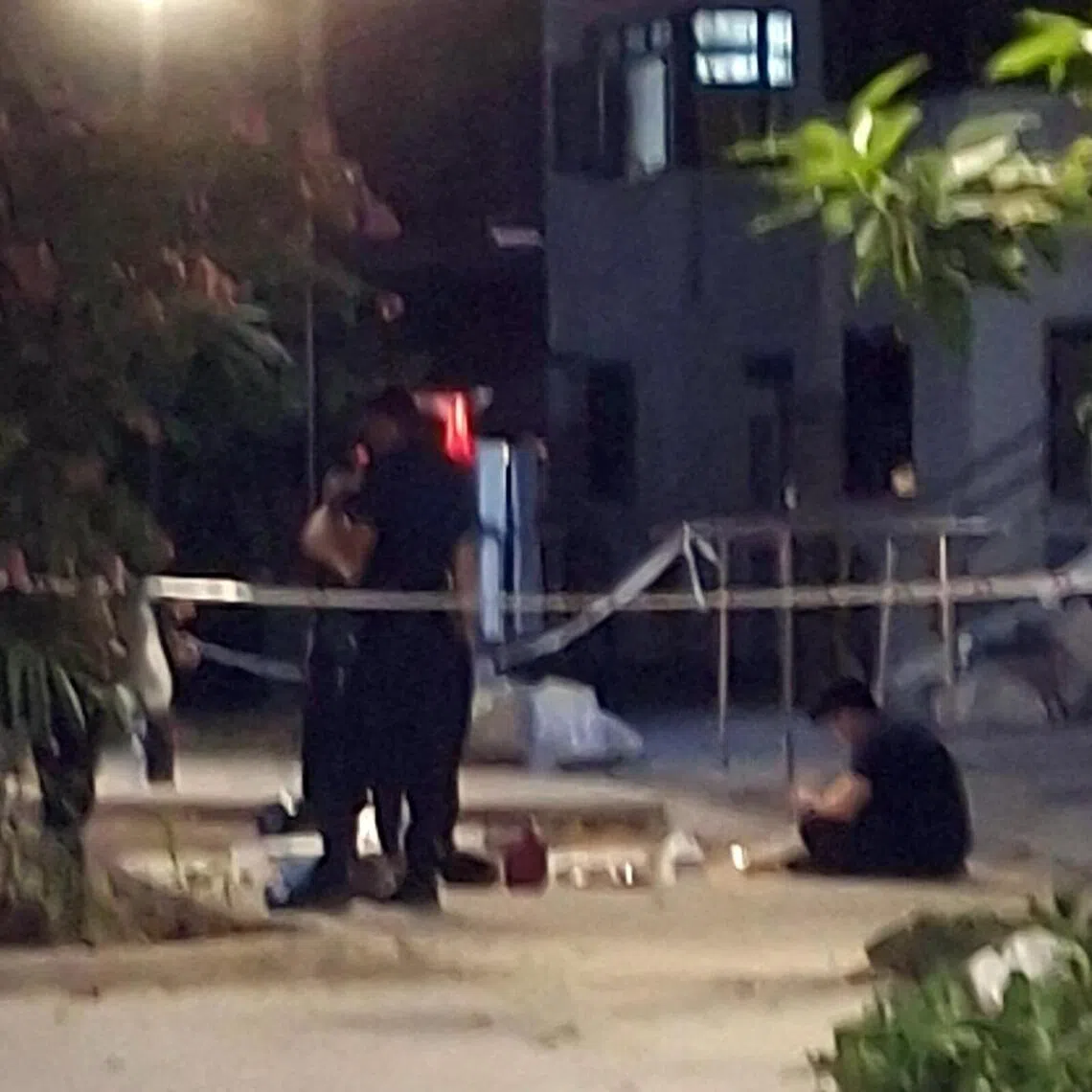 Several items are laid out on the ground behind a police cordon in Toa Payoh.