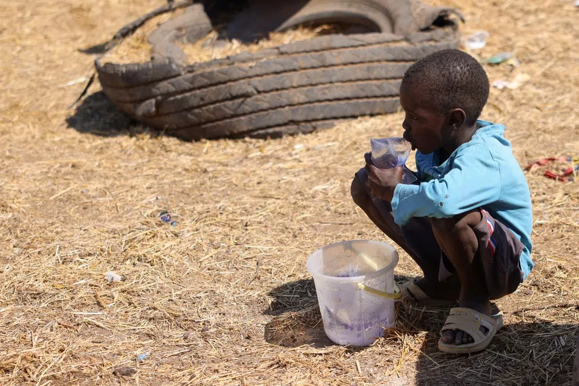 FILE PHOTO: A boy drinks water as he waits for customers to sell bags of water along a roadside on the outskirts of N’Djamena, Chad, November 15, 2025. REUTERS/Amr Abdallah Dalsh/File Photo