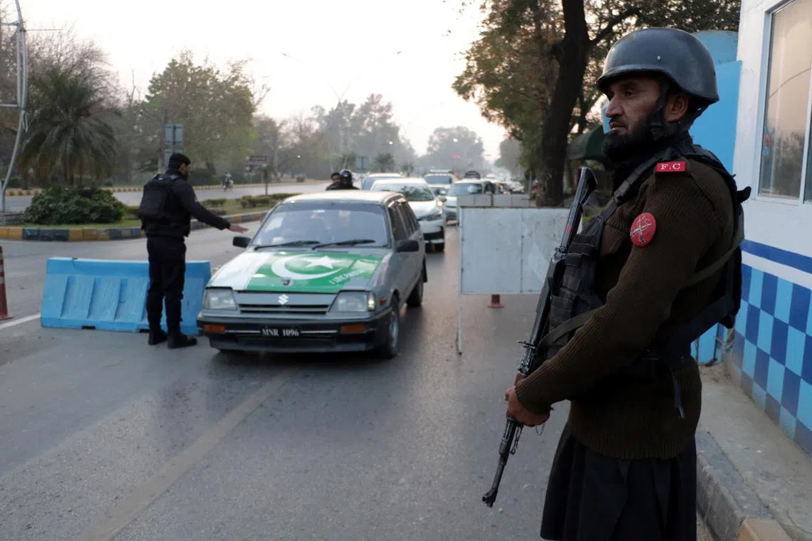Pakistani security officials control people and vehicles at a checkpoint a day after a suicide blast at Islamabad on Dec 23.