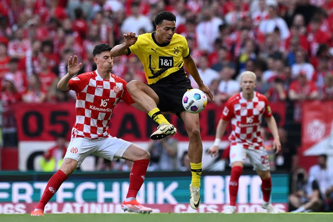 Dortmund's German midfielder Felix Nmecha and Mainz's Albanian forward Brajan Gruda vying for the ball in their  Bundesliga match in Mainz on May 11, 2024.