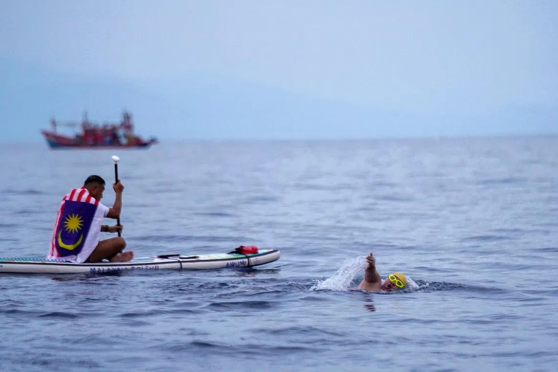 Mr Ridzwan Rahim, accompanied by a paddler, nearing his destination during his swim to Lang Tengah island on July 14.