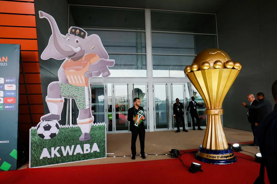 Soccer Football- Africa Cup of Nations draw.- The exhibition center of Abidjan, Ivory Coast - October 12, 2023. A man stands near the mascot and representation of the nation's African cup during the draw. REUTERS/Luc Gnago/ File photo