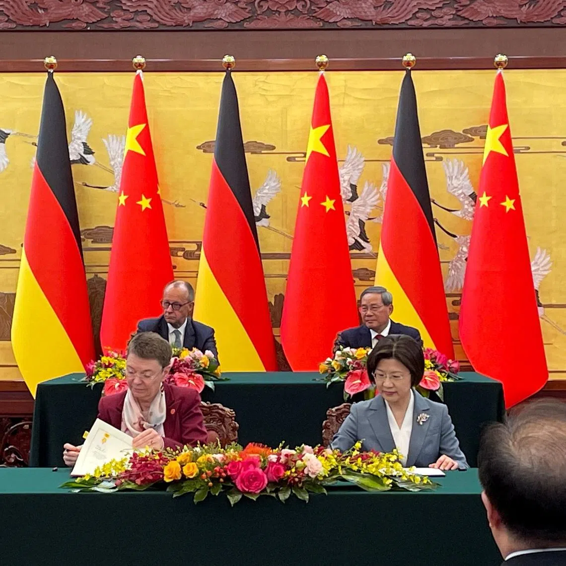 German Chancellor Friedrich Merz and Chinese Premier Li Qiang attend a signing ceremony at the Great Hall of the People in Beijing, China February 25, 2026. Picture taken with a mobile phone REUTERS/Andreas Rinke