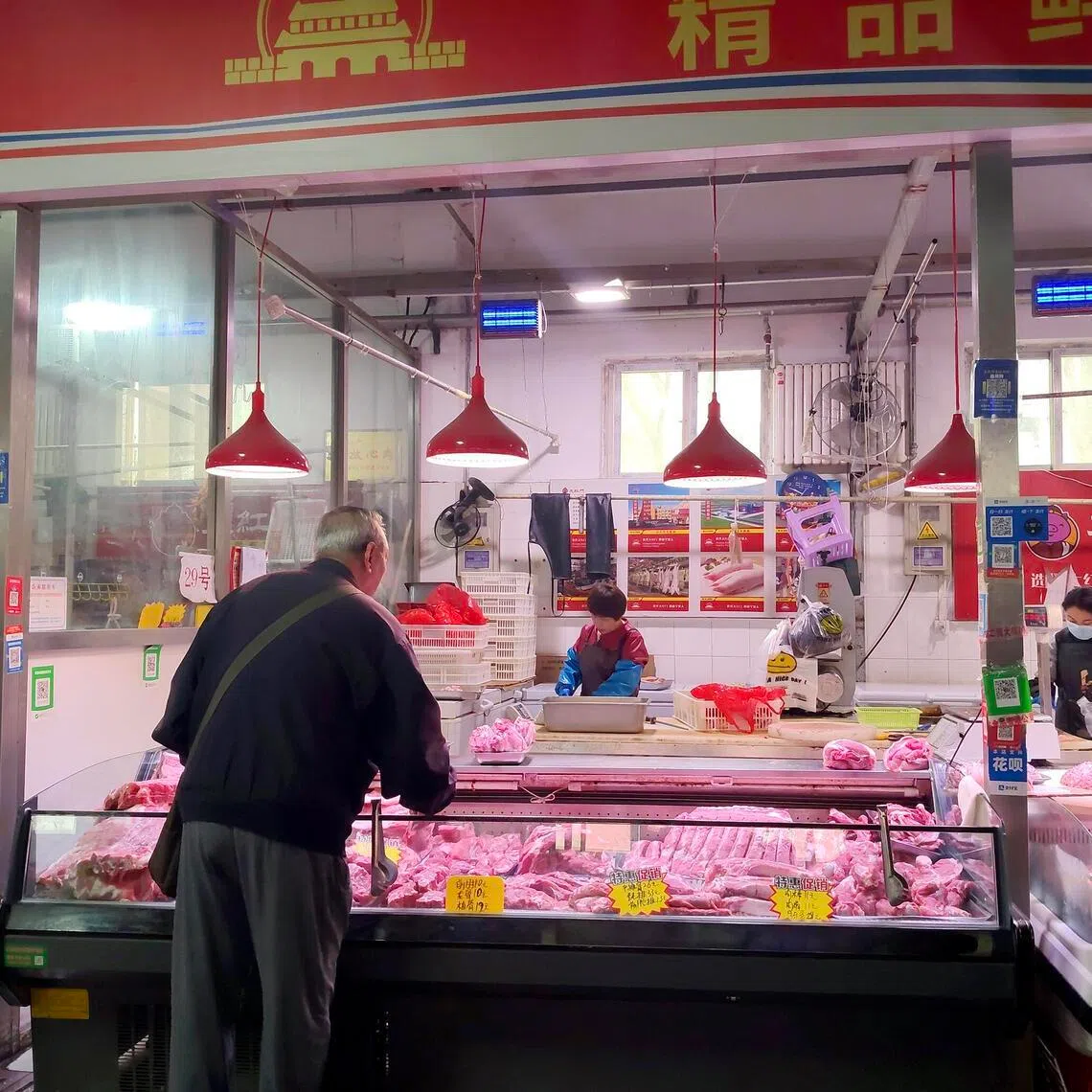 A man buys pork at a wet market in central Beijing on April 17.