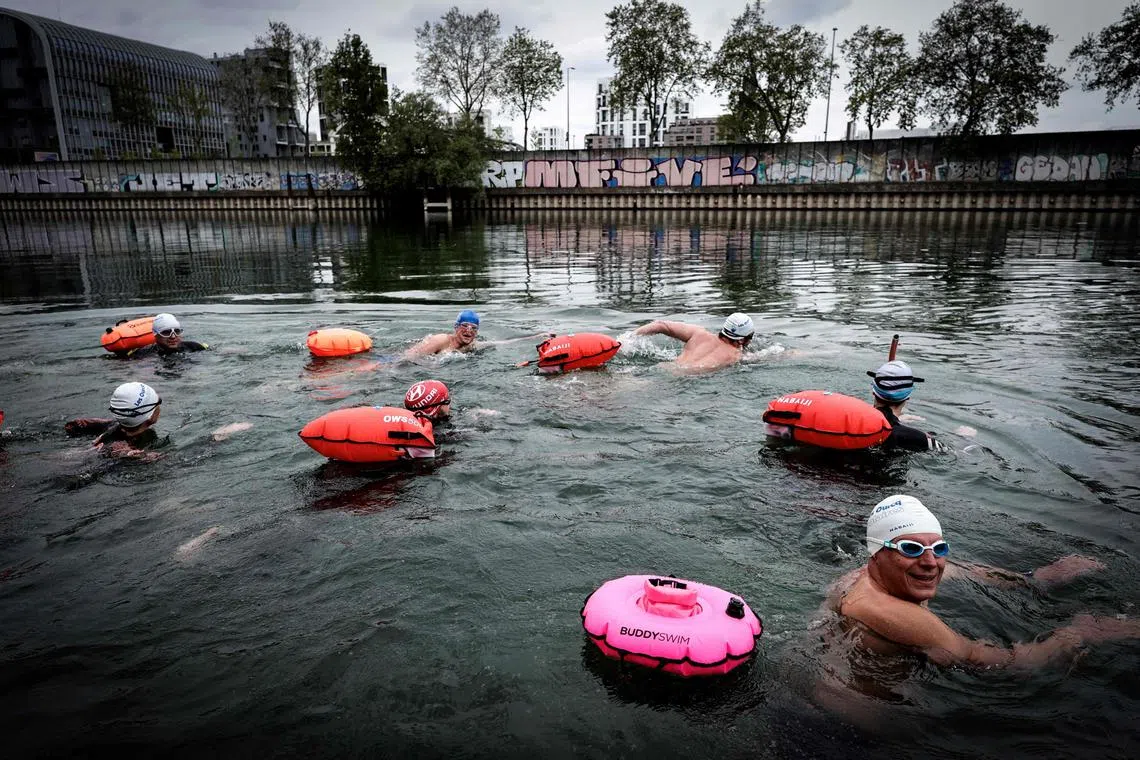 A group of swimmers bathe in the River Seine in Ile-Saint-Denis, north of Paris on May 1, 2024. The Seine is set to host the open-water swimming and triathlon during the July 26-Aug 11 Paris Olympics, providing that pollution can be reduced to safe levels.