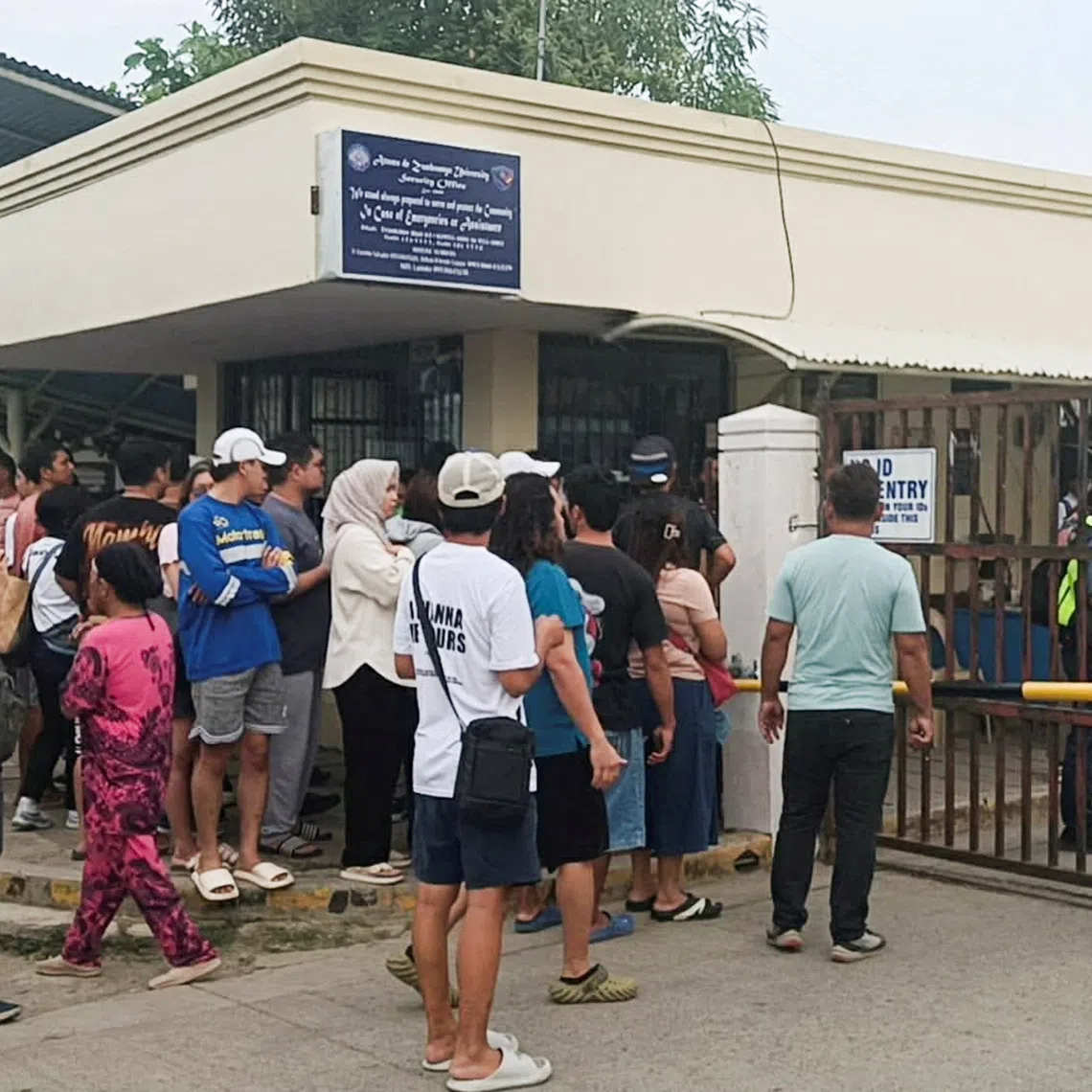 People stand outside Ateneo de Zamboanga University after a shooting that killed two people, in Zamboanga, southern Philippines, August 18, 2026. REUTERS/Nonoy Lacson