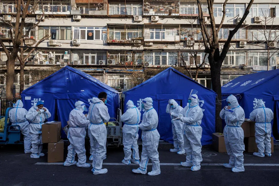 Pandemic prevention workers gather before their shift to look after buildings where residents do home quarantine, as Covid-19 outbreaks continue in Beijing, on Dec 8, 2022. 