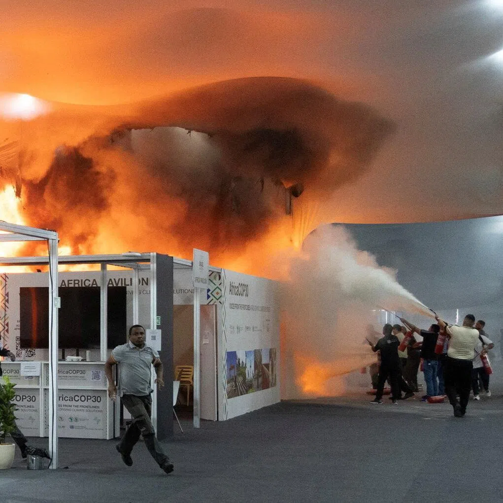People using fire extinguishers to put out a fire at COP30 on Nov 20.