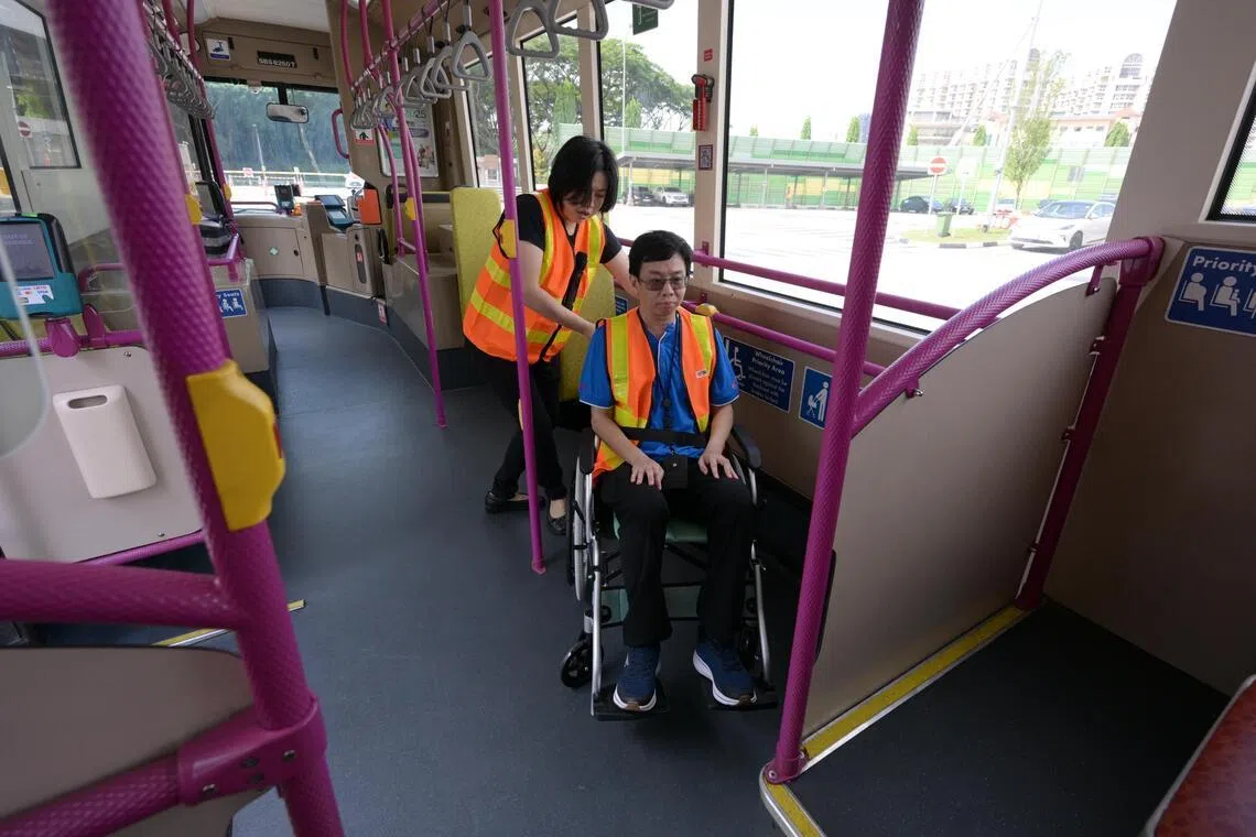 Kris Loy (R), 50, associate trainer with SBS Transit and SG Enable demonstrates how a wheelchair user could be helped into the bus. The demonstration was done at the official  opening of the new Public Transport Inclusivity Training Centre (PTITC) on April 10, 2026.