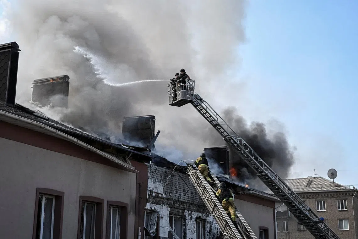 Firefighters work at the site of a building hit by a Russian drone strike, amid Russia's attack on Ukraine, in Zaporizhzhia, Ukraine, April 13, 2026. REUTERS/Stringer