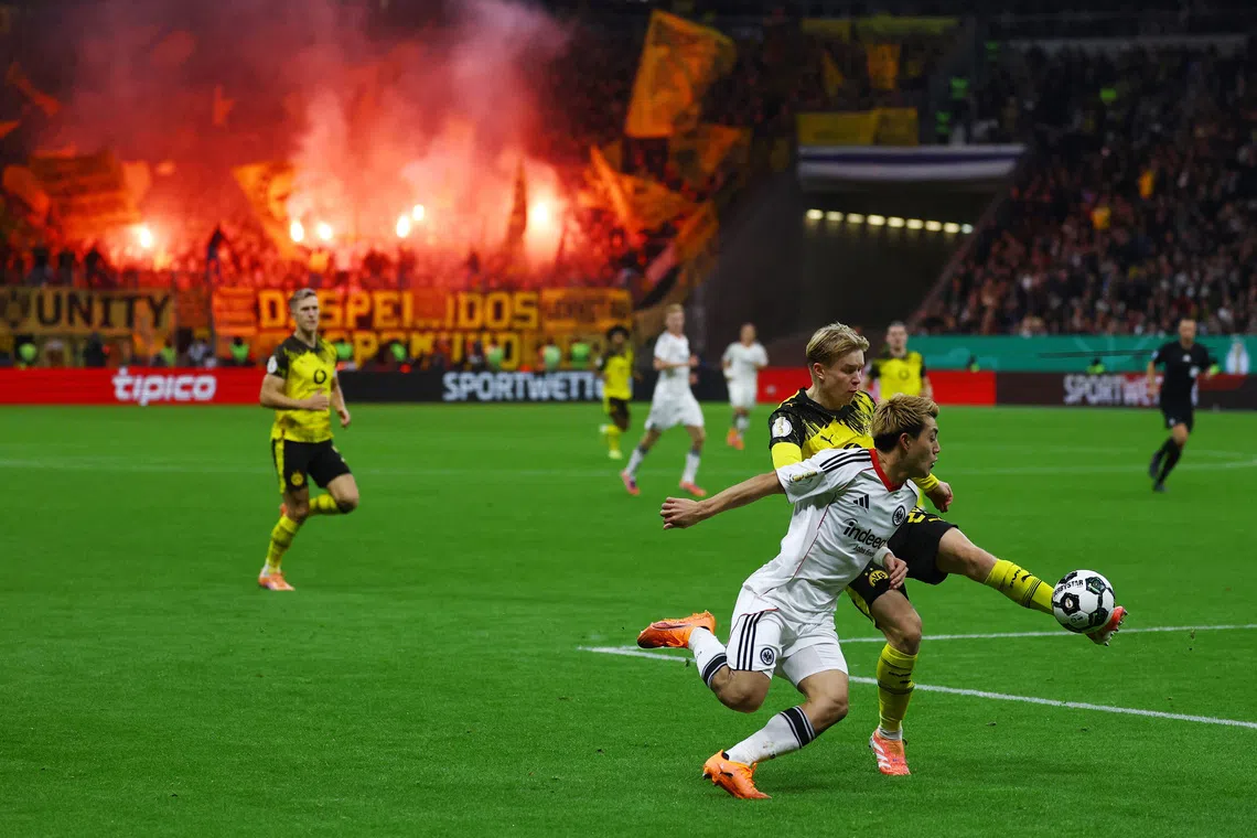 Soccer Football - DFB Cup - Second Round - Eintracht Frankfurt v Borussia Dortmund - Deutsche Bank Park, Frankfurt, Germany - October 28, 2025 Eintracht Frankfurt's Ritsu Doan in action with Borussia Dortmund's Daniel Svensson REUTERS/Kai Pfaffenbach
