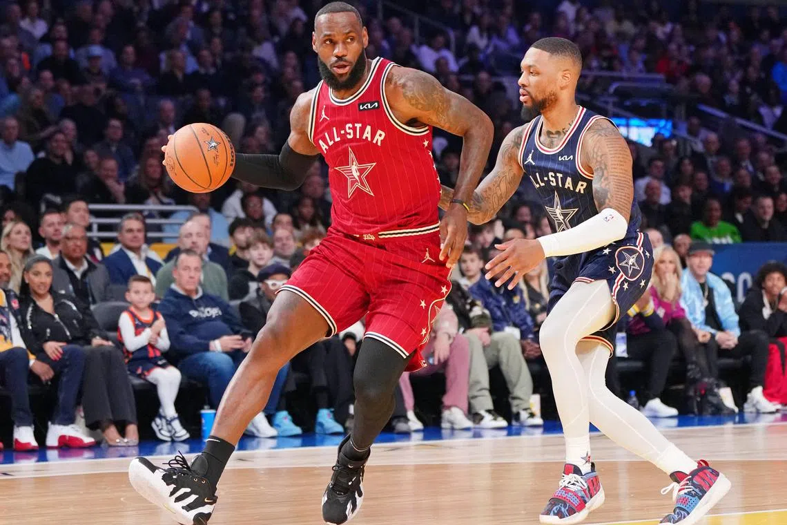 Western Conference forward LeBron James (left) of the Los Angeles Lakers dribbling the ball against Eastern Conference guard Damian Lillard of the Milwaukee Bucks during the first half of the 73rd NBA All Star game at Gainbridge Fieldhouse.
