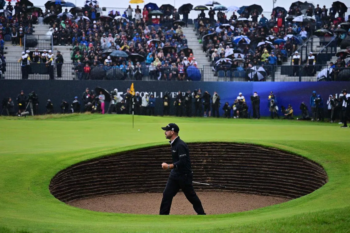 US golfer Brian Harman celebrates playing out of a bunker onto the 18th green.