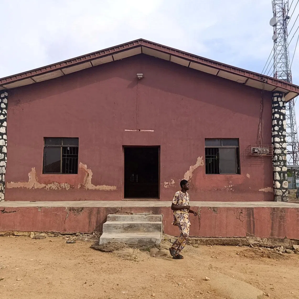 FILE PHOTO: A person walks outside the Christ Apostolic Church during a Sunday service held for those killed and kidnapped in an attack by gunmen on November 18, in the town of Eruku, Kwara state, Nigeria, November 23, 2025. REUTERS/Abdullahi Dare Akogun/File Photo