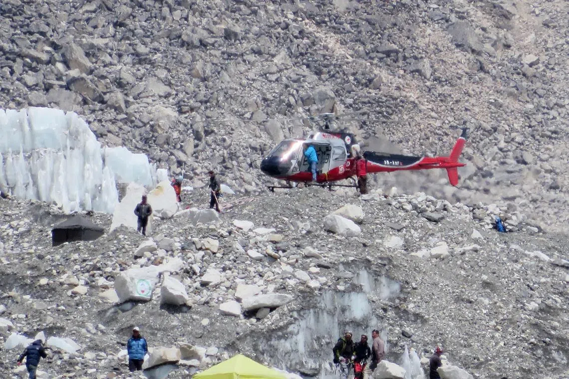 (FILES) This photograph taken on April 18, 2014 shows a Nepalese rescue helicopter landing at Everest Base Camp during rescue efforts following an avalanche that killed sixteen Nepalese sherpas in the Khumbu icefall at the base of Mount Everest. Ten years ago, Nepali mountain guide Dawa Tashi Sherpa was fighting for his life after being hit by an avalanche on Everest, the deadliest disaster on the world's highest mountain. The accident, which killed 16 Nepali guides on April 18, 2014, shone a spotlight on the huge dangers they face to let high-paying foreign clients reach their dreams. (Photo by Robert KAY / AFP) / TO GO WITH: Nepal-Mountaineering-Everest-Avalanche-Anniversary, FOCUS by Paavan MATHEMA