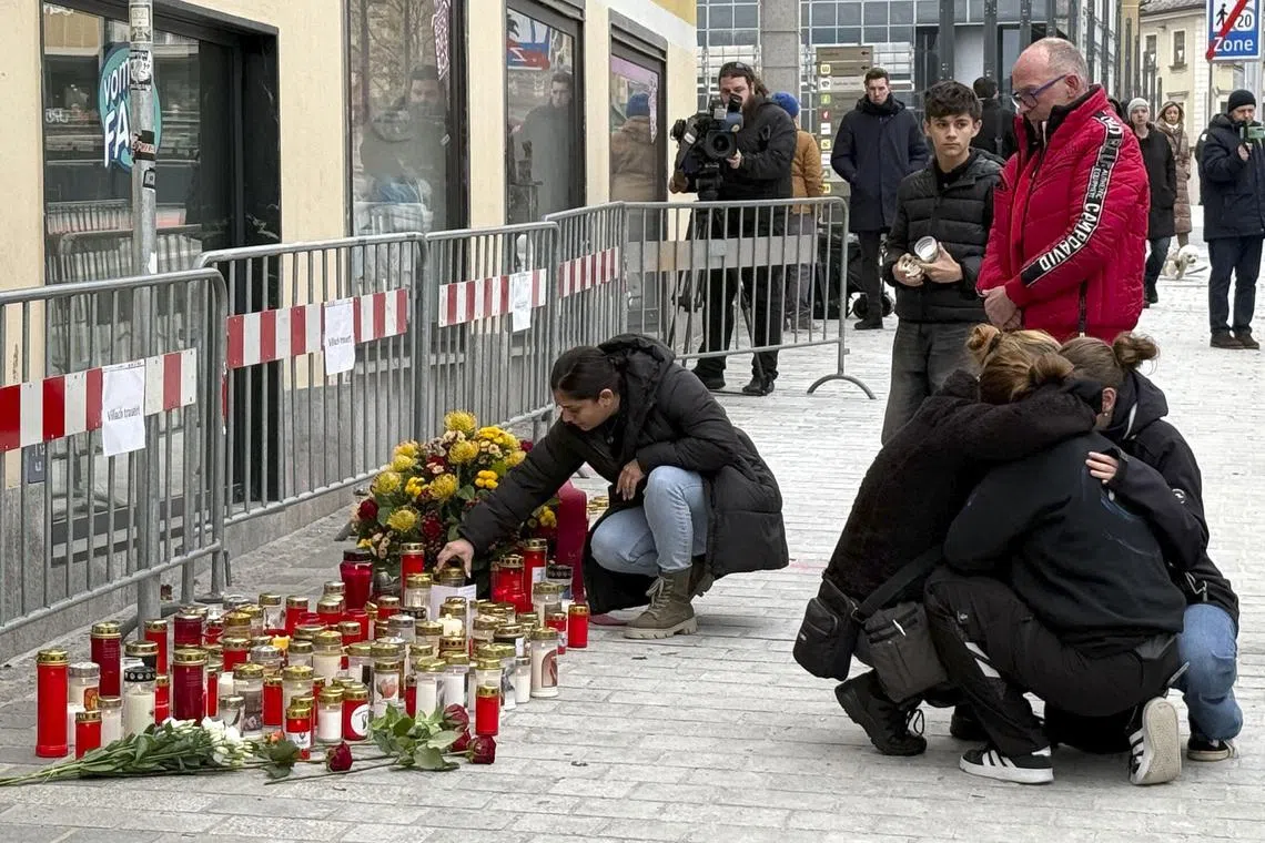 People mourning on Feb 16, 2025, in the Austrian town of Villach, at a makeshift memorial where a man the previoius day randomly attacked passers-by with a knife.