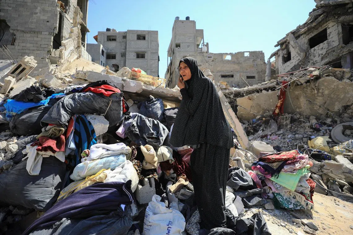 A Palestinian woman inspects the damage, after Israeli forces withdrew from Shejaiya neighbourhood, following a ground operation, in the eastern part of Gaza City.