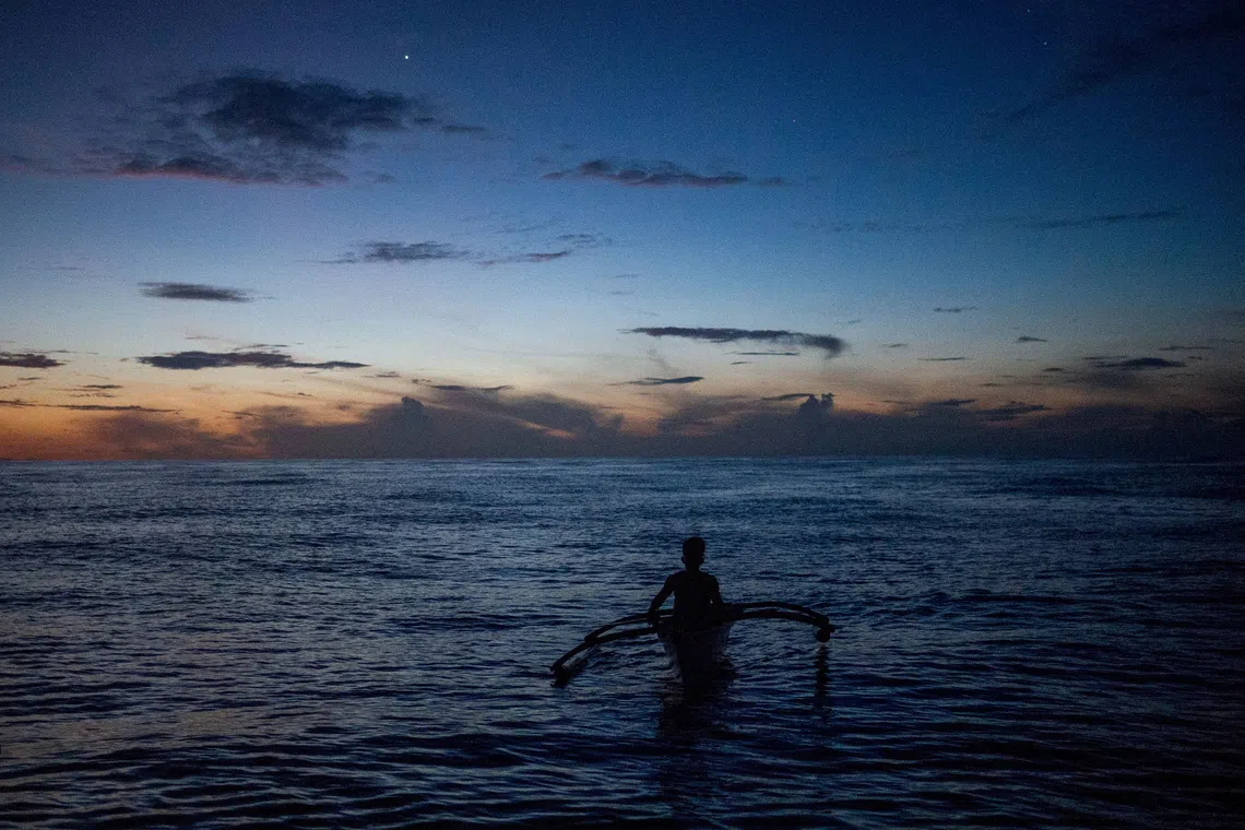 FILE PHOTO: A Filipino fisheman rows a boat during a trip near the disputed Scarborough Shoal, in Masinloc, Zambales province, Philippines, July 18, 2022.  REUTERS/Lisa Marie David/File Photo