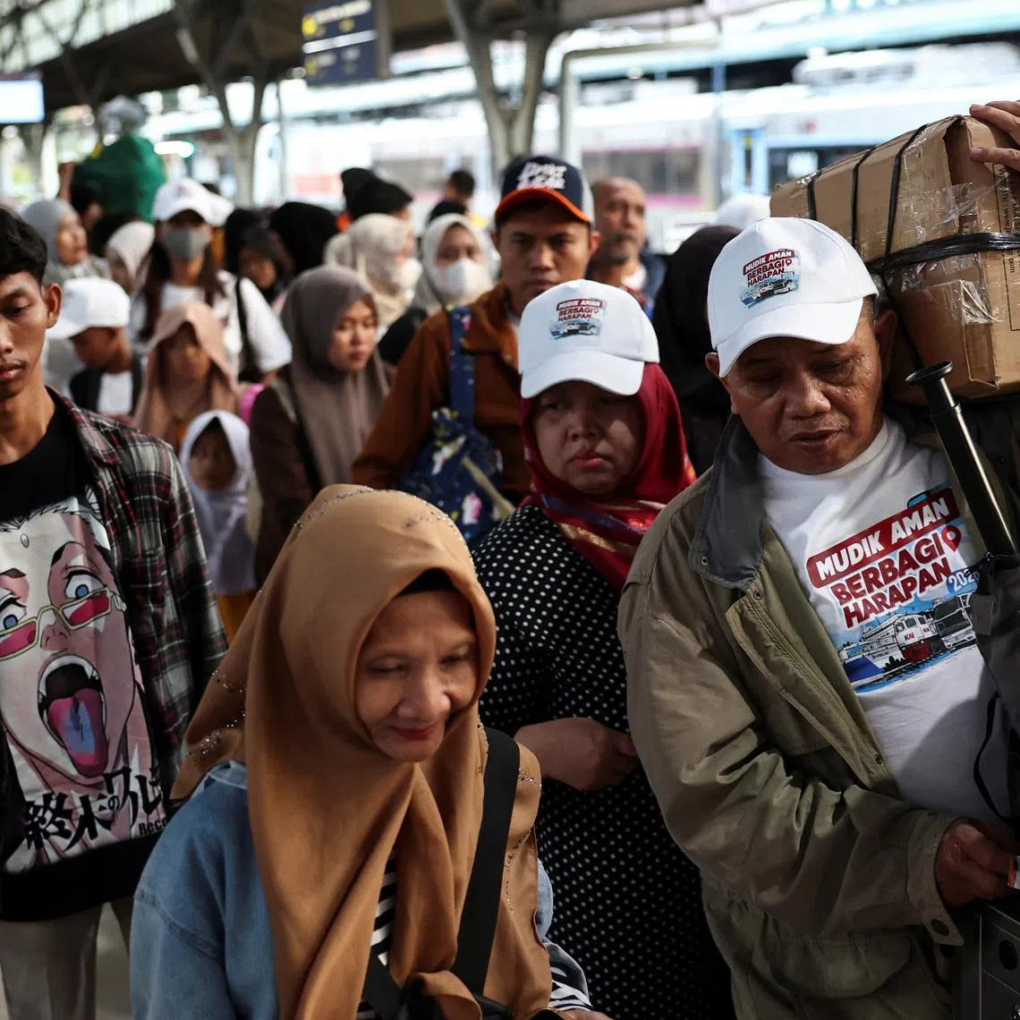 Passengers carrying luggage queue at Pasar Senen train station, as people travel to their hometowns to celebrate Eid al-Fitr, known locally as 'Mudik', in Jakarta, Indonesia, March 16, 2026. REUTERS/Willy Kurniawan