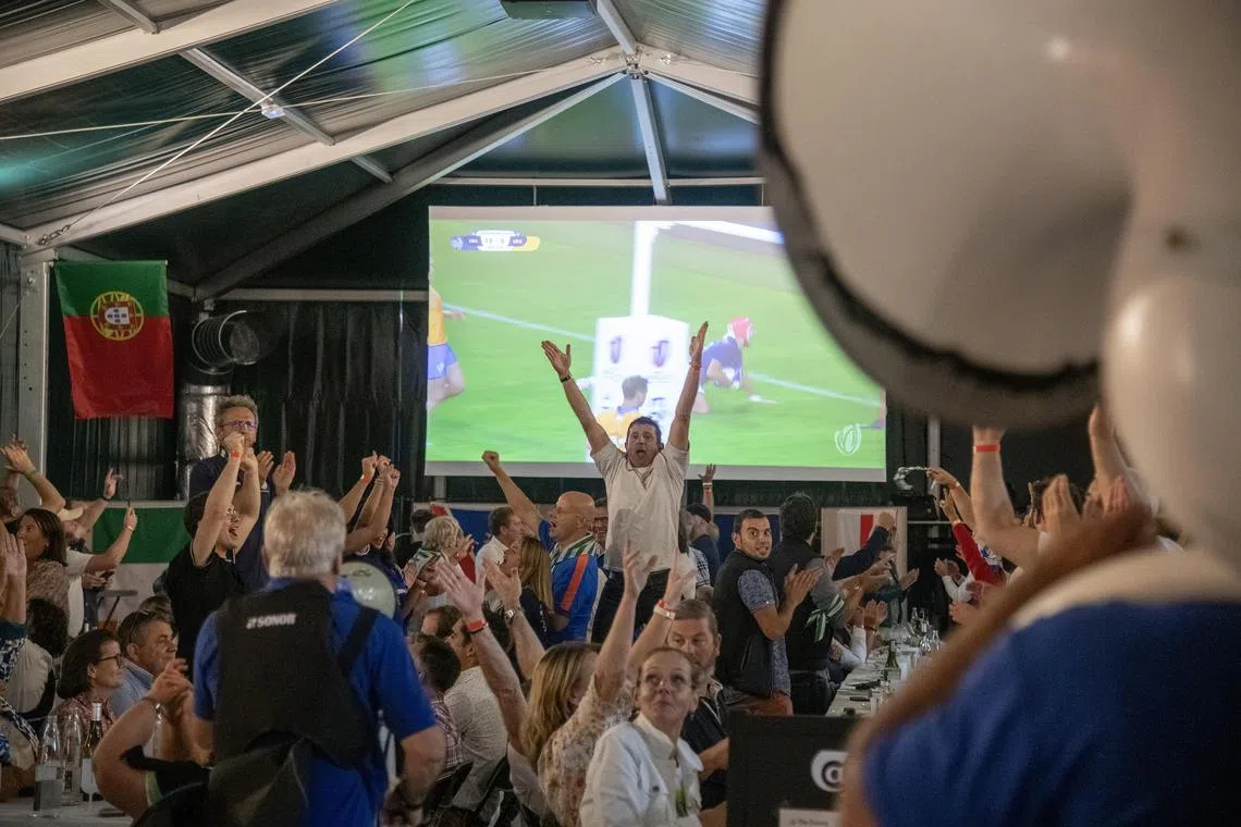 Fans celebrate a French try while watching France play Uruguay in the Rugby World Cup.