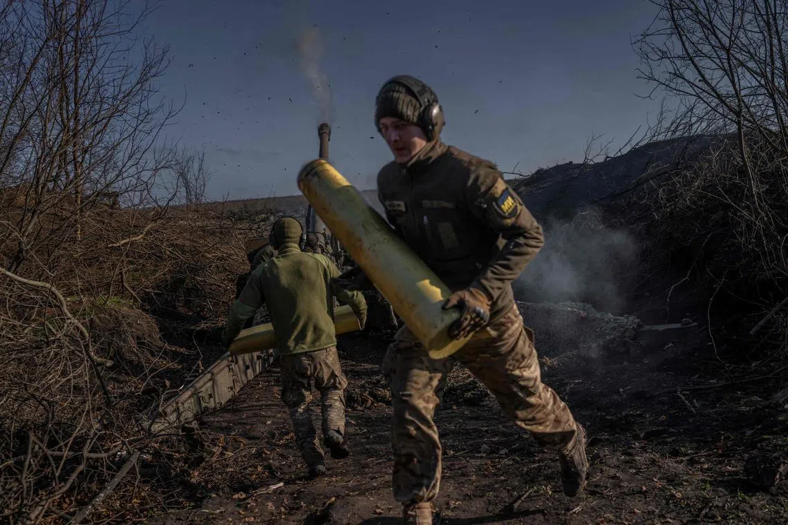 Ukrainian servicemen fire artillery towards Russian positions outside Bakhmut, in November 2022.