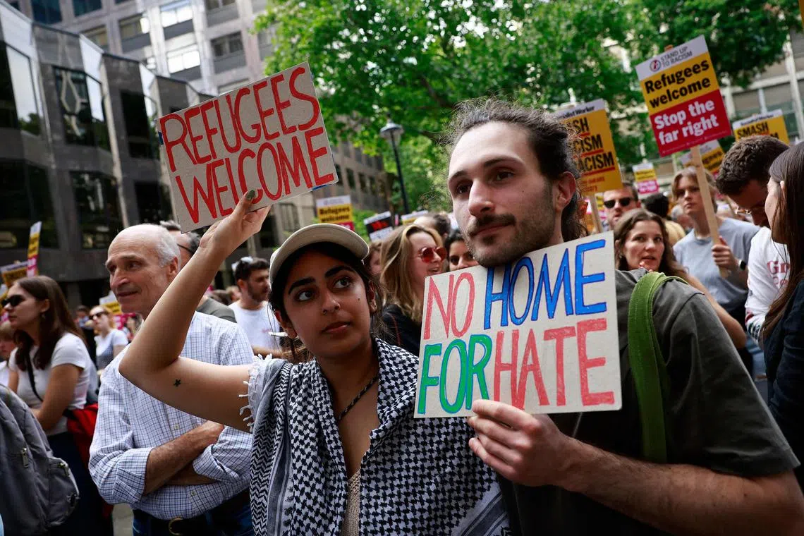 People hold anti-racist placards as they take part in a “Stop the Far-Right” demonstration in London.
