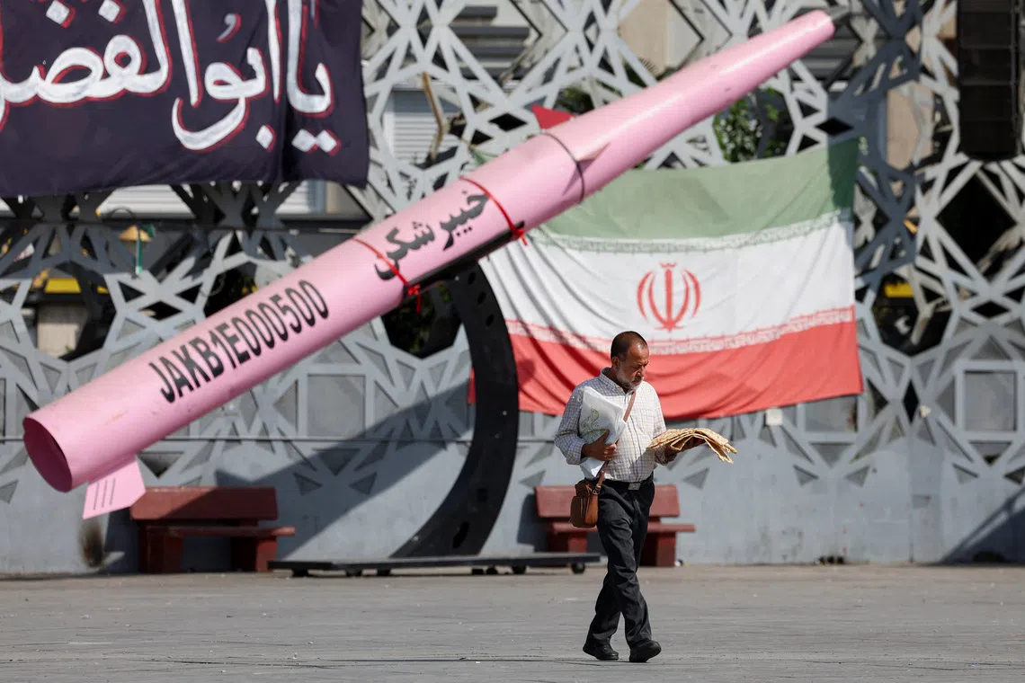 A man walks next to a symbolic mockup of an Iranian missile and an Iranian flag at Imam Hussein Square in Tehran, Iran, July 12, 2026. Majid Asgaripour/WANA (West Asia News Agency) via REUTERS