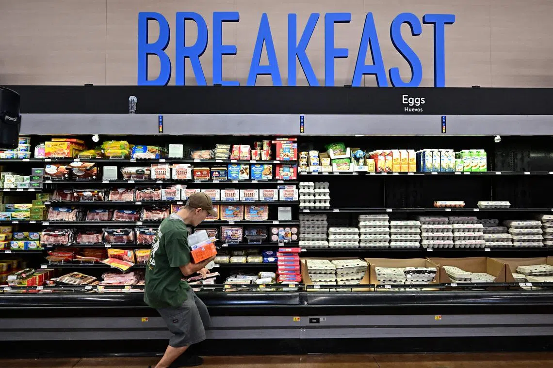 (FILES) A shopper picks up his package of bacon while shopping for food items at a grocery store on August 14, 2024 in Rosemead, California. Donald Trump's US election victory was, at least in part, down to his success in pinning the blame for a post-pandemic inflationary surge on the Biden-Harris administration. But analysts say some of Trump's own economic plans, from hiking tariffs to reining in the Fed's independence, risk undoing the US central bank's progress against inflation, potentially pushing it to keep interest rates higher for longer. (Photo by Frederic J. BROWN / AFP)