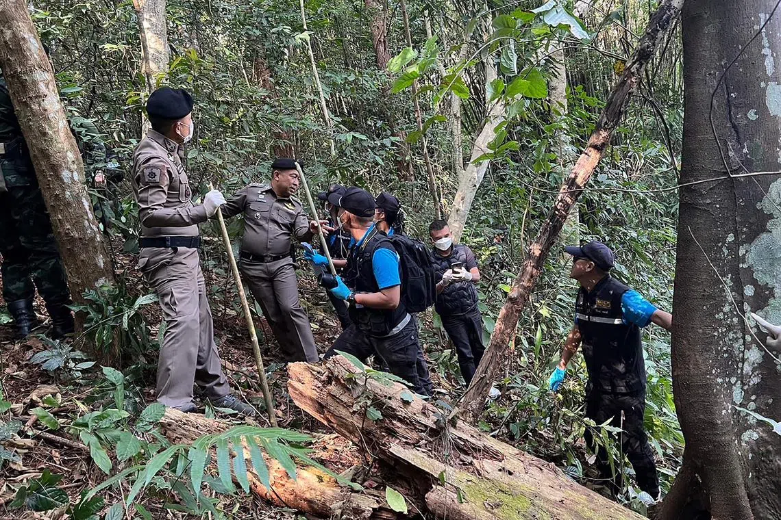 This handout photo released on Jan 12, 2023 by the Royal Thai Army's Pha Muang Task Force shows members of the Pha Muang Task Force and Thai security personnel walking through a forested area of Chiang Rai province in northern Thailand, following a clash with suspected drug traffickers.