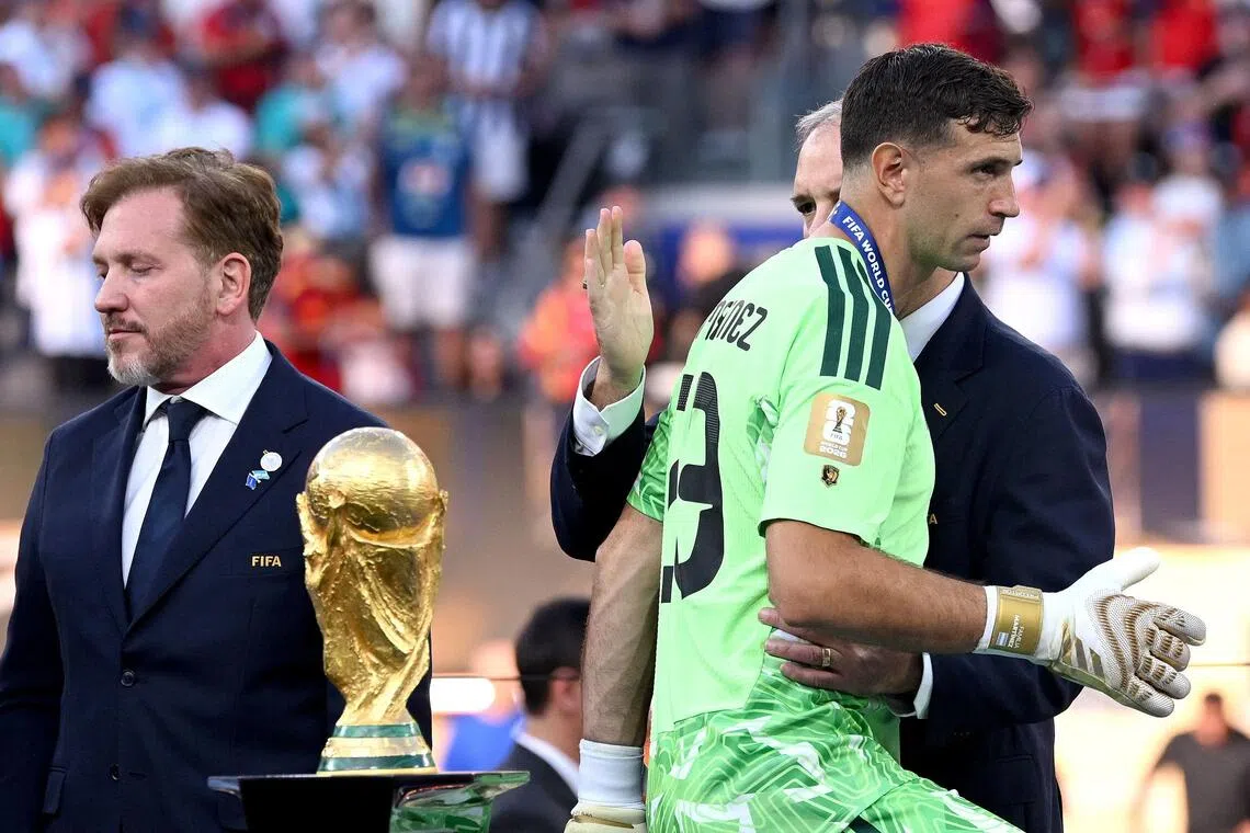 Emiliano Martinez of Argentina walking past the FIFA World Cup trophy at the award ceremony on July 19. The Aston Villa goalkeeper played 810 minutes at the tournament.