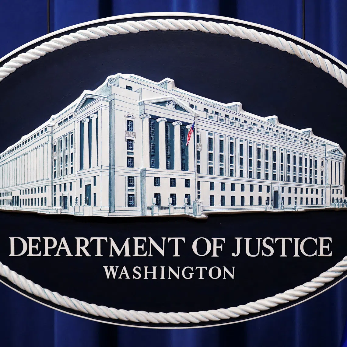 A U.S. Justice Department logo or seal showing Justice Department headquarters, known as \"Main Justice,\" is seen behind the podium in the Department's headquarters briefing room before a news conference with the Attorney General in Washington, January 24, 2023.  REUTERS/Kevin Lamarque