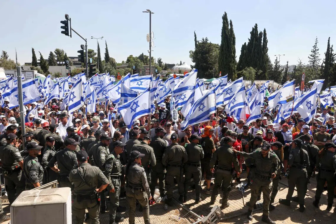 Israeli security forces standing guard as protesters demonstrate at the entrance of the Knesset, Israel's parliament, in Jerusalem on July 24, 2023.