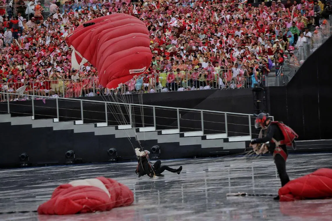 2WO Shirley Ng gliding on the wet surface as she lands during National Day Parade  2024 at the Padang on Aug 9, 2024. 