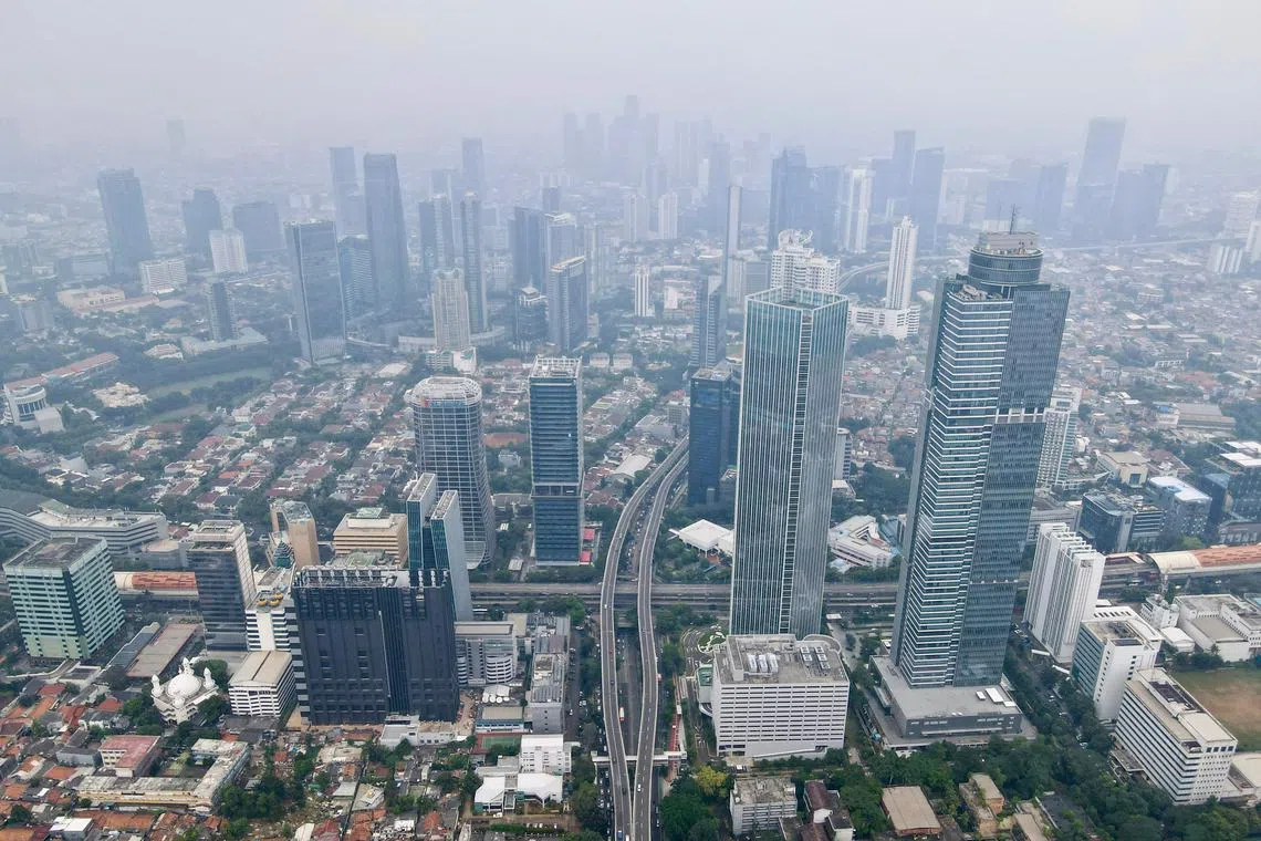 An aerial view shows haze over the Jakarta skyline on May 14, 2024. (Photo by BAY ISMOYO / AFP)